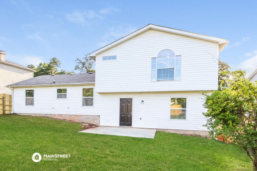 a white house with a green lawn and a blue sky