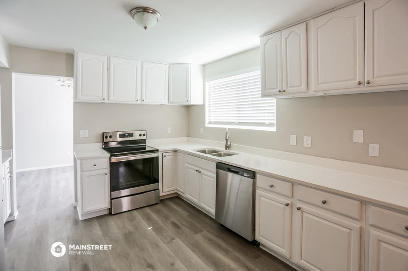 a kitchen with white cabinets and stainless steel appliances