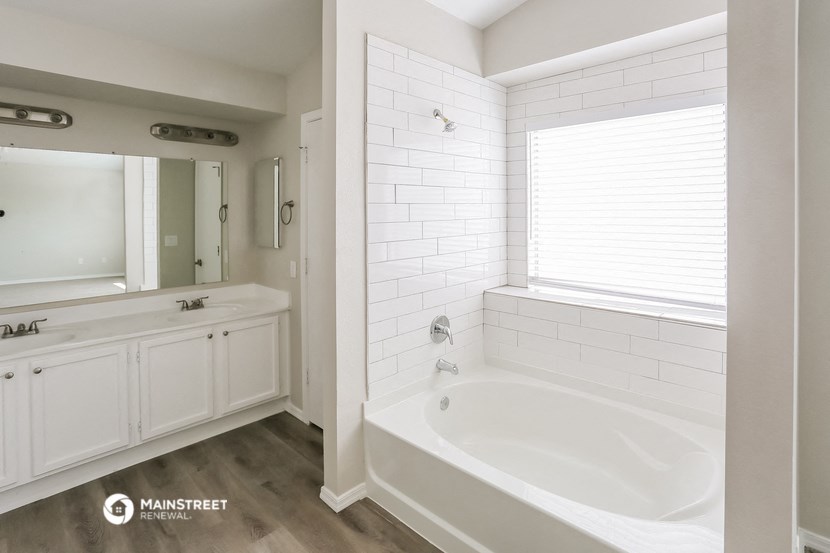 a white bathroom with a tub and a sink