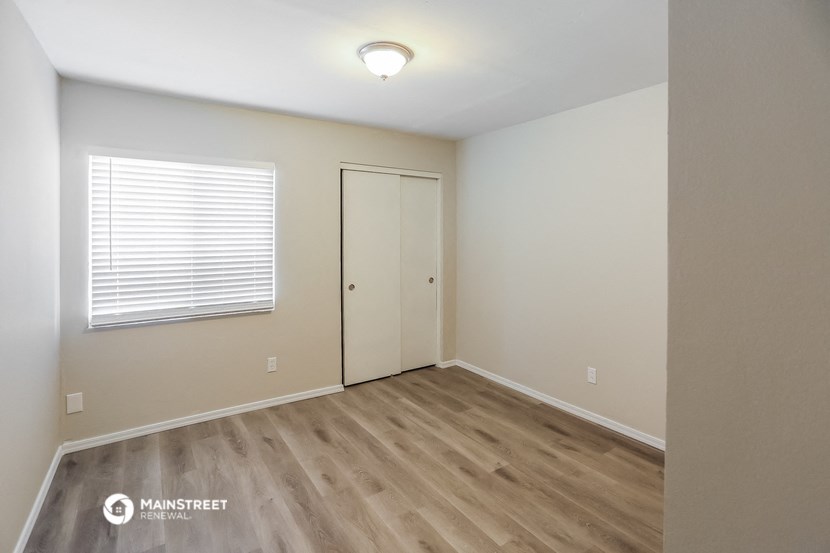 the upstairs bedroom with a door to the closet and a window