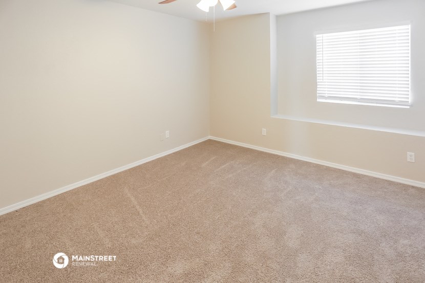 an empty room with carpet and a window