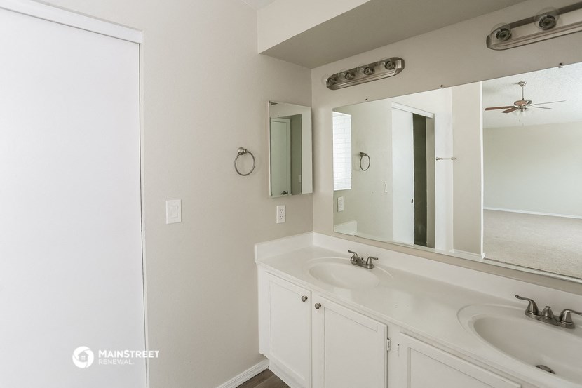 a bathroom with two sinks and a large mirror