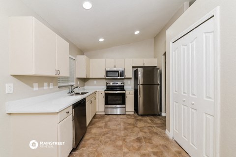 a white kitchen with stainless steel appliances and white cabinets