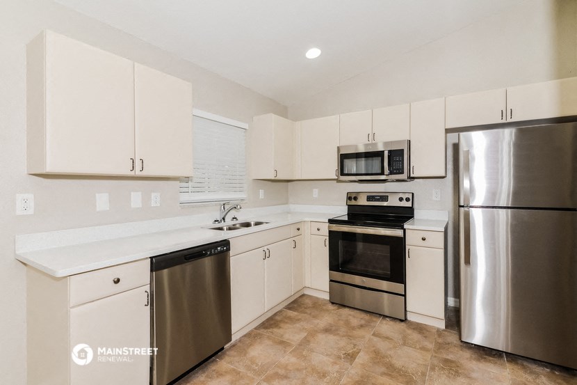 a white kitchen with stainless steel appliances and white cabinets