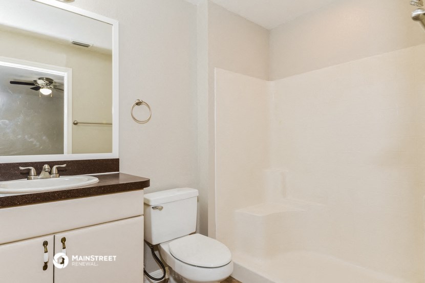 a bathroom with a toilet and a sink and a mirror