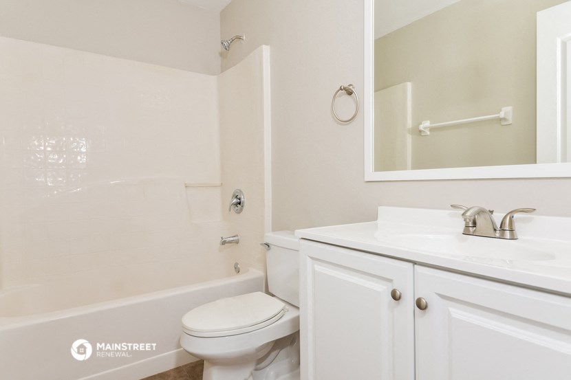 a bathroom with a sink toilet and a mirror