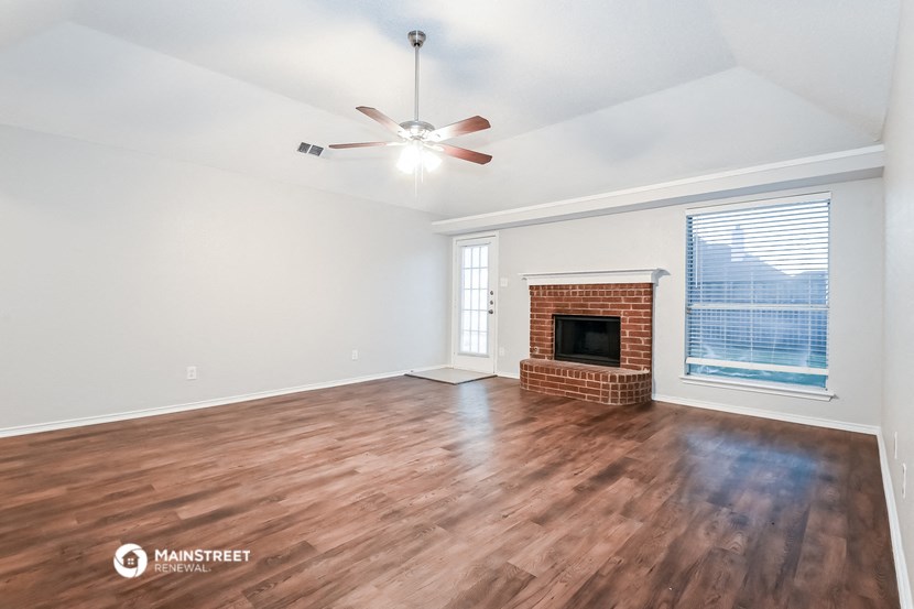 a living room with a fireplace and a ceiling fan
