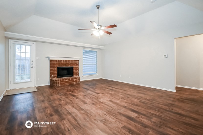 the living room with wood flooring and a fireplace