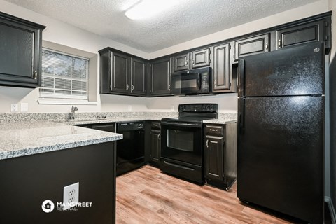 the kitchen of a home with black appliances and granite counter tops