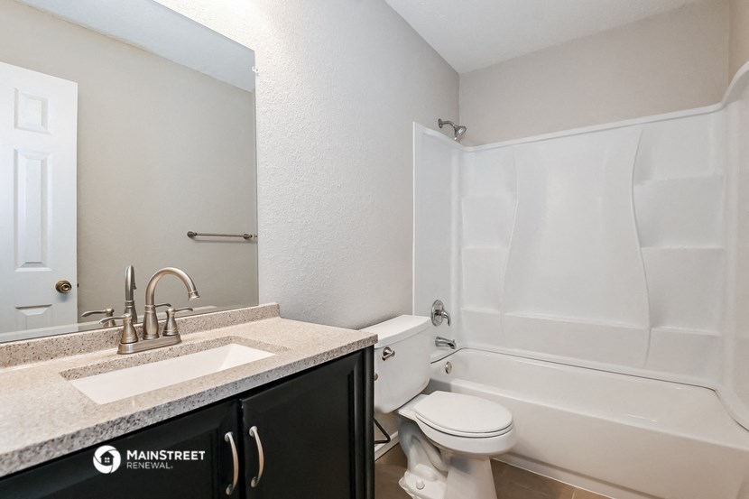a bathroom with a sink toilet and bath tub