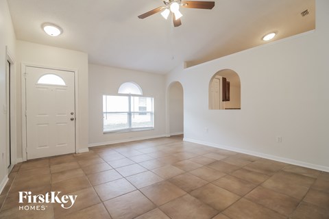 A spacious room with a ceiling fan and a door leading to a balcony.