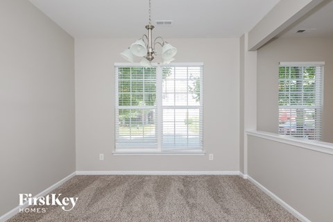 a living room with carpet and a chandelier