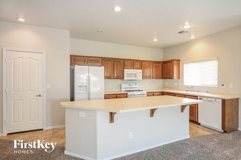 A kitchen with a white island and wooden cabinets.