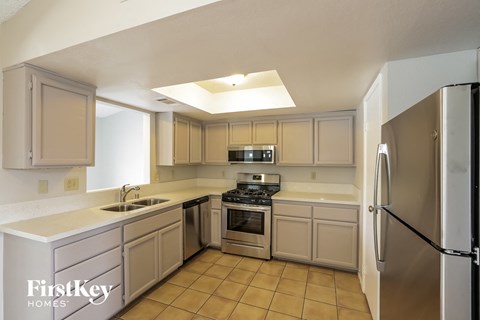 a kitchen with white cabinets and stainless steel appliances