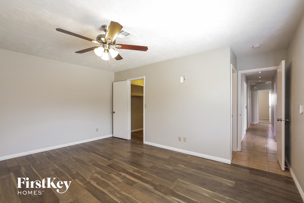 the living room and hallway of an empty house with a ceiling fan