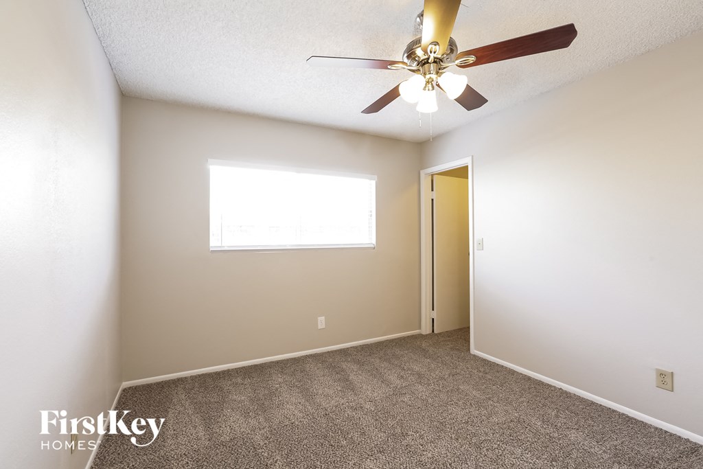 a bedroom with a ceiling fan and a door to a closet