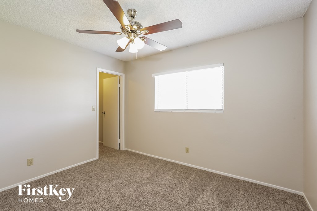 a bedroom with a ceiling fan and a door to a closet