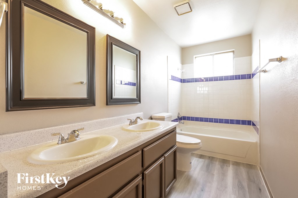 a bathroom with two sinks and a shower and a toilet