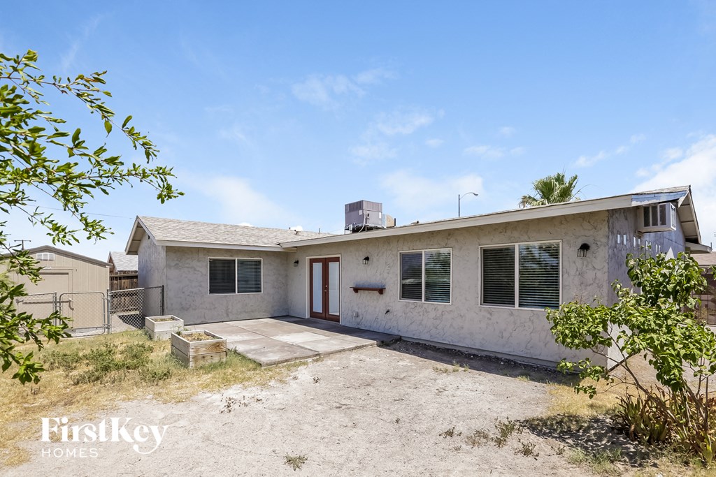 a small white house with a yard and a driveway