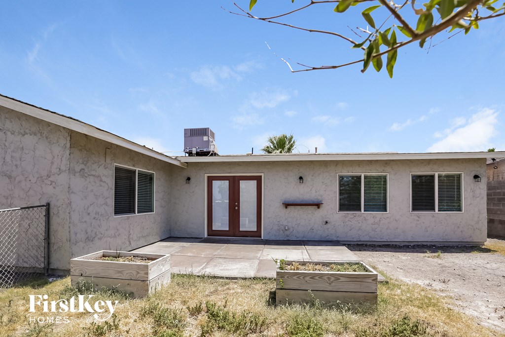 a small white house with a red door and two planters