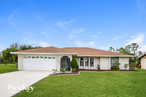 a white house with a lawn and a garage