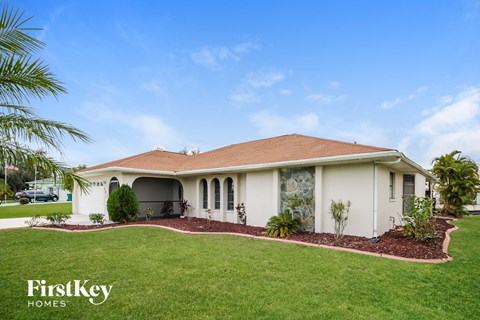 a house with a lawn and a palm tree