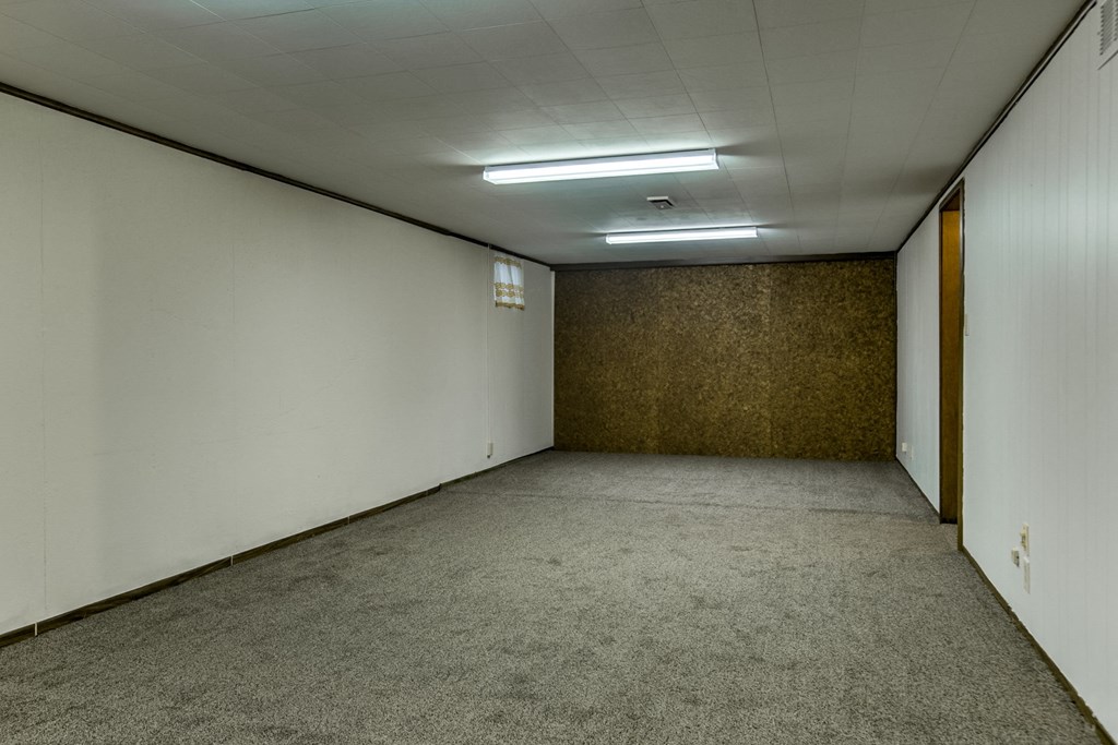 an empty room with white walls and a concrete floor and a door