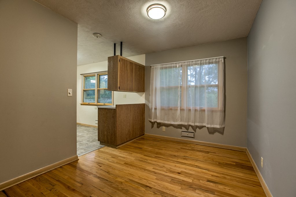 an empty living room with a curtain on the window