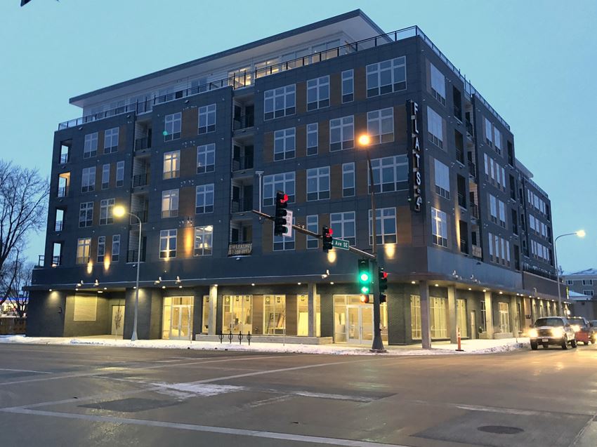 an apartment building on the corner of a city street at night