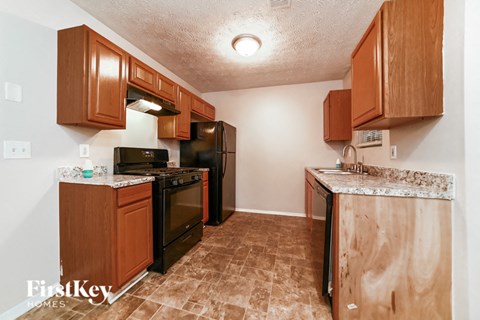 A kitchen with wooden cabinets and black appliances.