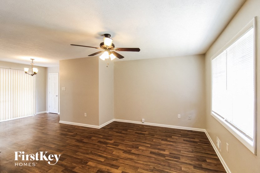 a living room with wood flooring and a ceiling fan
