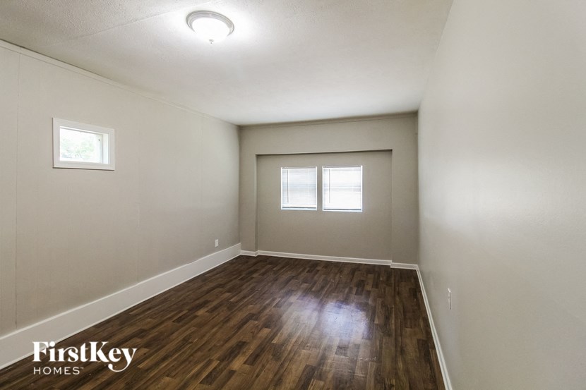 the spacious living room with hardwood flooring and two windows