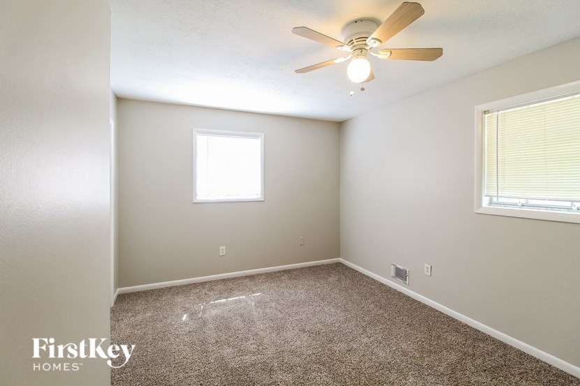 a empty room with a ceiling fan and a window