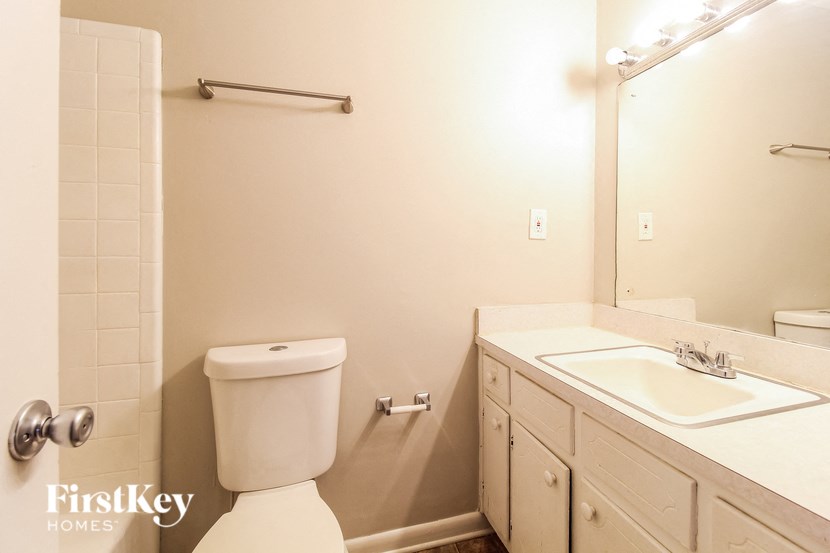 a white bathroom with a toilet and a sink