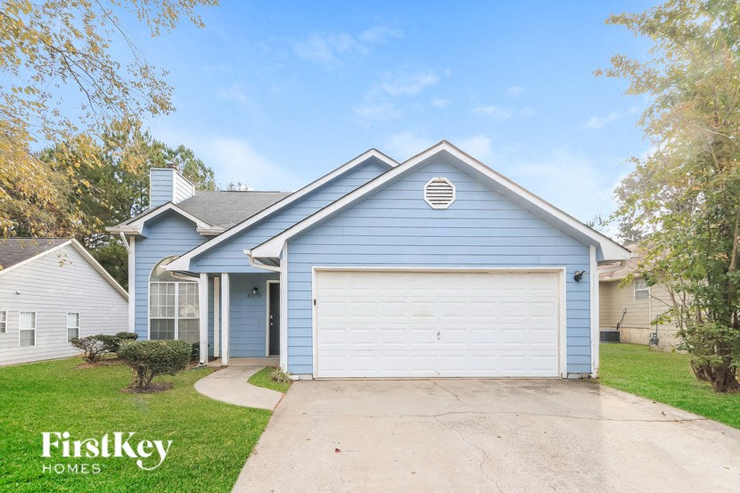 A blue house with a white garage door is for sale.