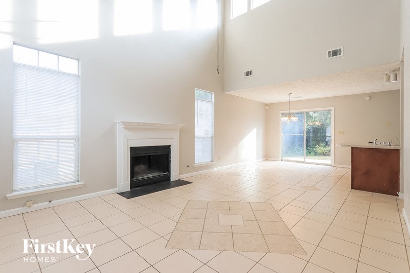 A spacious living room with a fireplace and large windows.