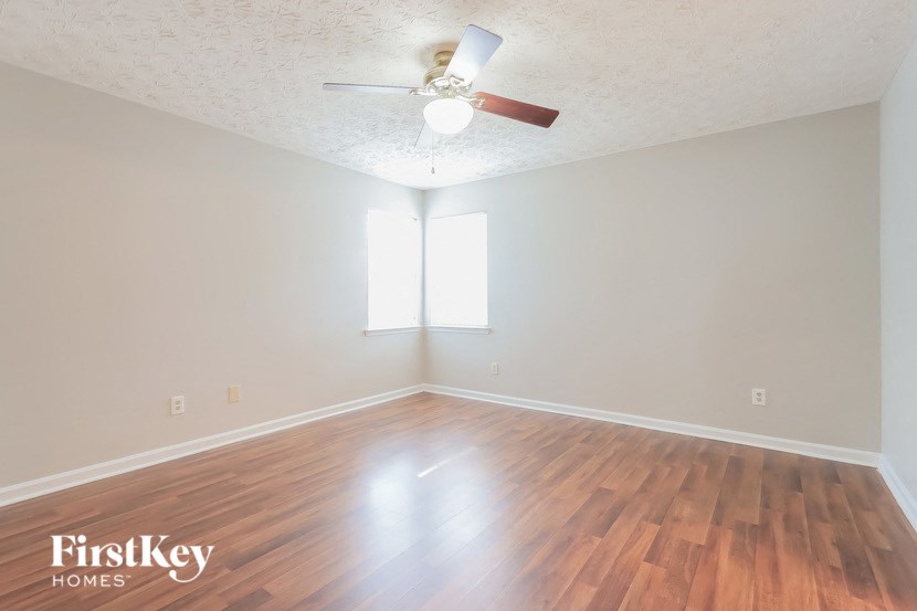 A room with wooden floors and a ceiling fan.