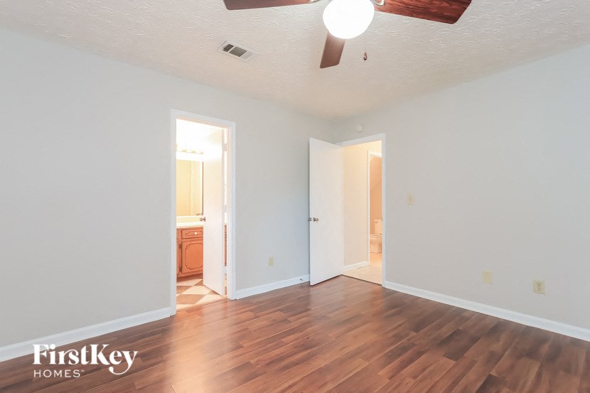 A room with wooden floors and a ceiling fan.