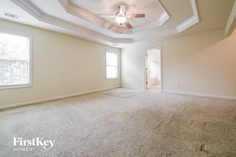 a living room with carpet and a ceiling fan