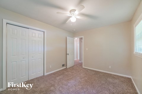 a bedroom with a ceiling fan and a closet