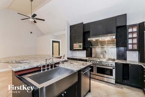 A modern kitchen with a stainless steel sink and oven.
