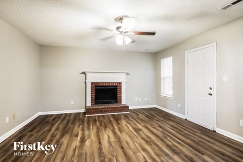 A room with a fireplace and a ceiling fan.