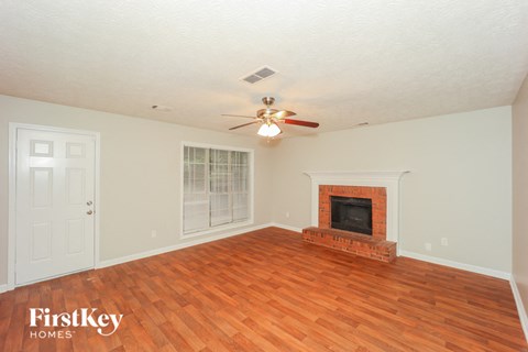 A room with a fireplace and a ceiling fan.