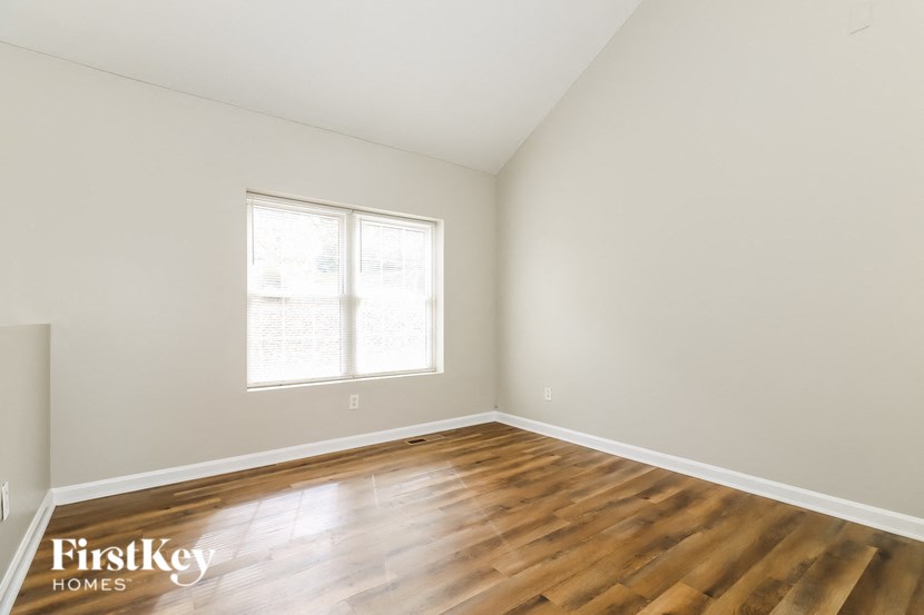 the living room of a home with wooden floors and a window