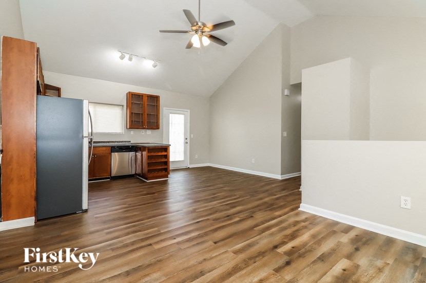 the living room and kitchen of an empty house with wood flooring