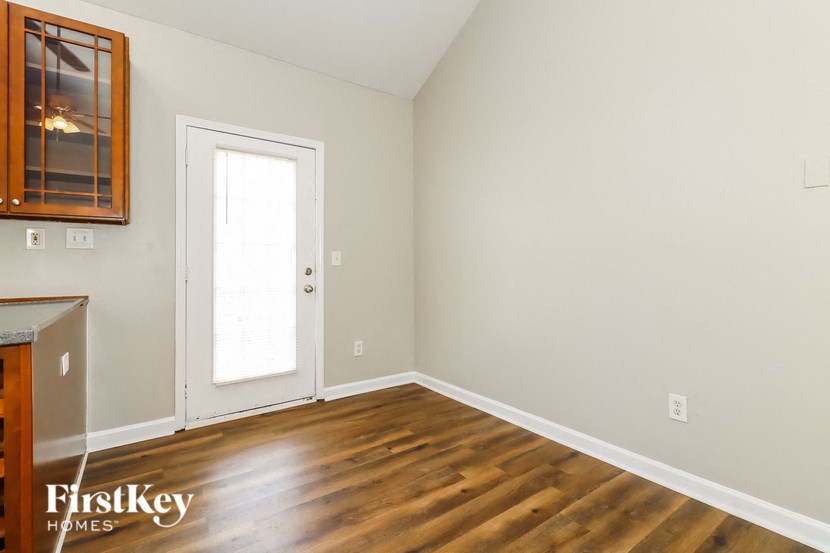 a living room with wood floors and white walls and a door