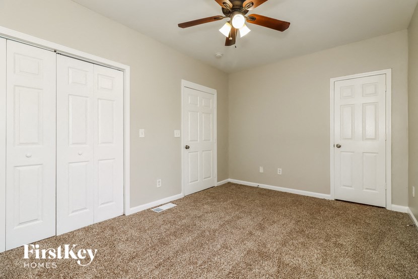 a bedroom with two closets and a ceiling fan