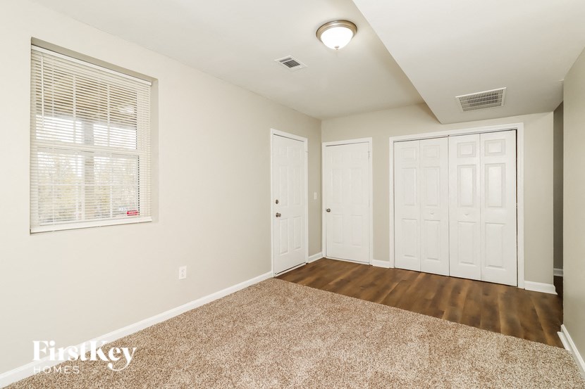 a bedroom with two closets and a window and a door