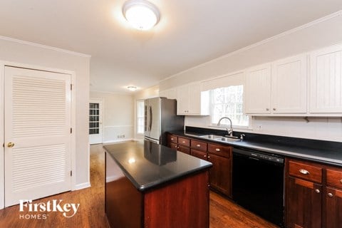 A kitchen with a black counter top and wooden cabinets.