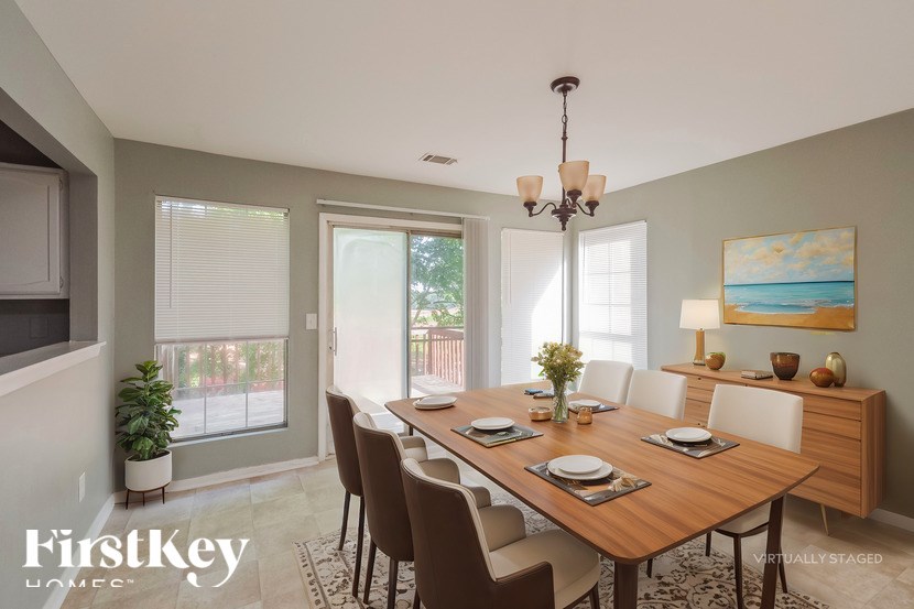 A dining room with a wooden table set for six.